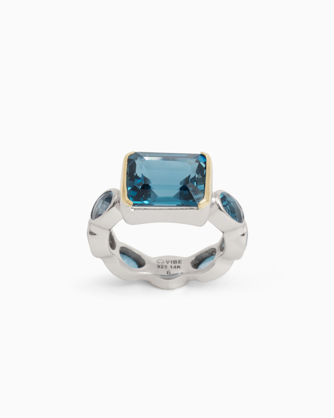 A sterling silver ring with a central square London blue topaz stone and smaller oval London blue topaz stones around the band, featuring a 14K gold accent around the center stone.
